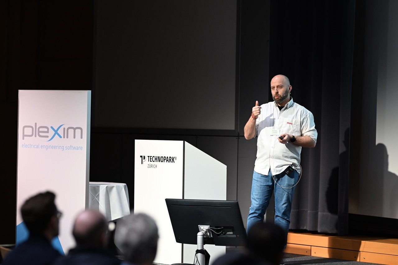Riccardo Tinivella gesturing while presenting on stage at Technopark Zürich
